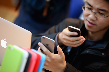 一名中国顾客正在北京的一家苹果专卖店设置新买的iPhone 6。 一名中国顾客正在北京的一家苹果专卖店设置新买的iPhone 6。