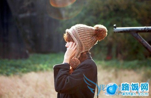 戴帽儿配耳机并且一手抚脸侧唯美拍照姿势